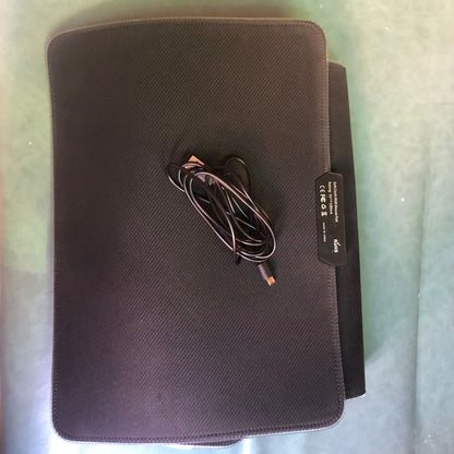 Black electronic device with a cable on a light green surface