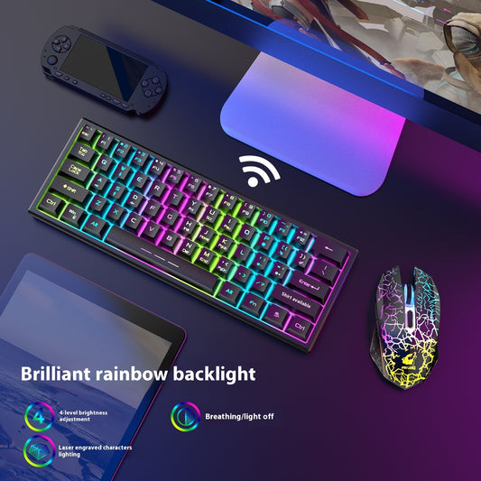 Gaming keyboard with colorful backlighting on a desk with a mouse and handheld console.
