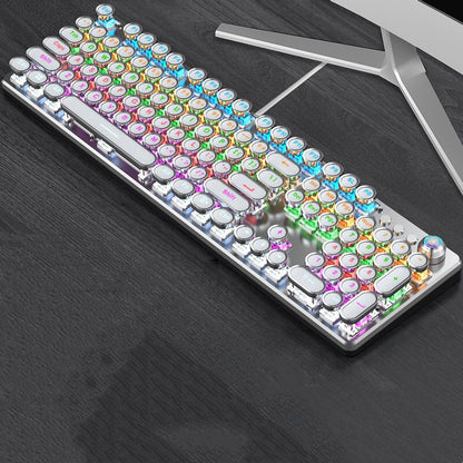 Colorful keyboard on a dark surface with a computer monitor in the background