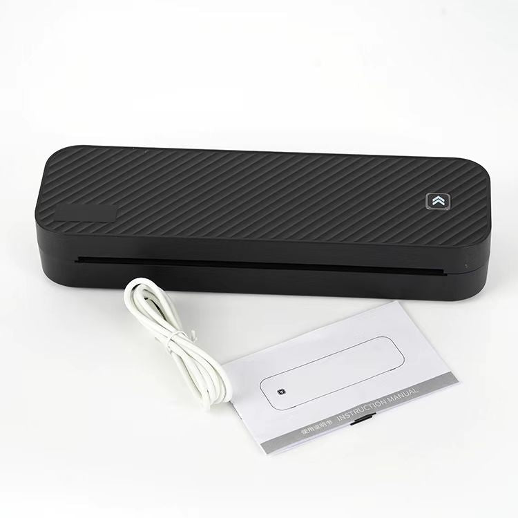 Black rectangular device with a cable and manual on a white background