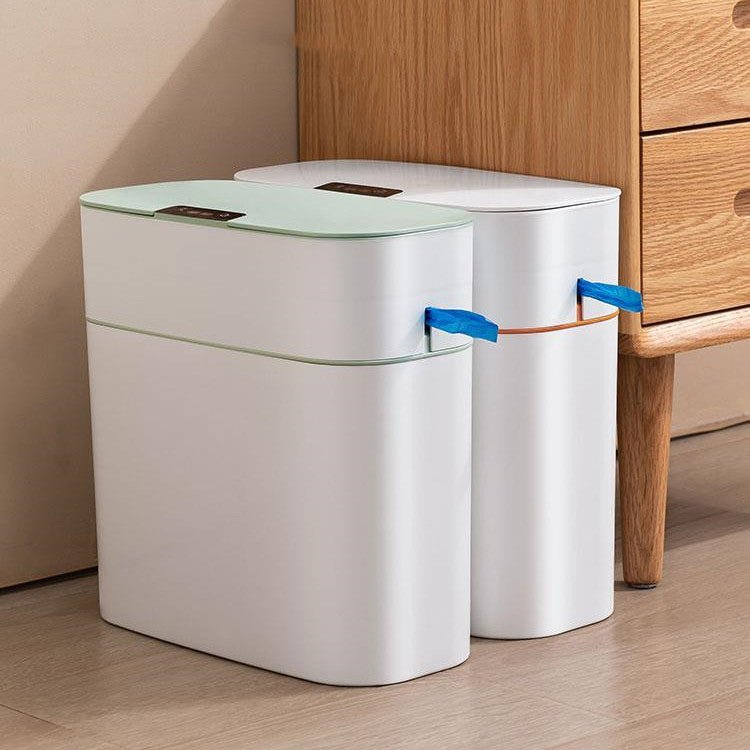 Two white trash bins with green lids on a wooden floor.