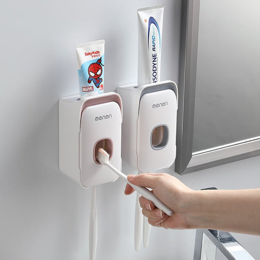 Hand using a toothbrush with a toothpaste dispenser attached to a wall, featuring a Marvel Spider-Man tube.