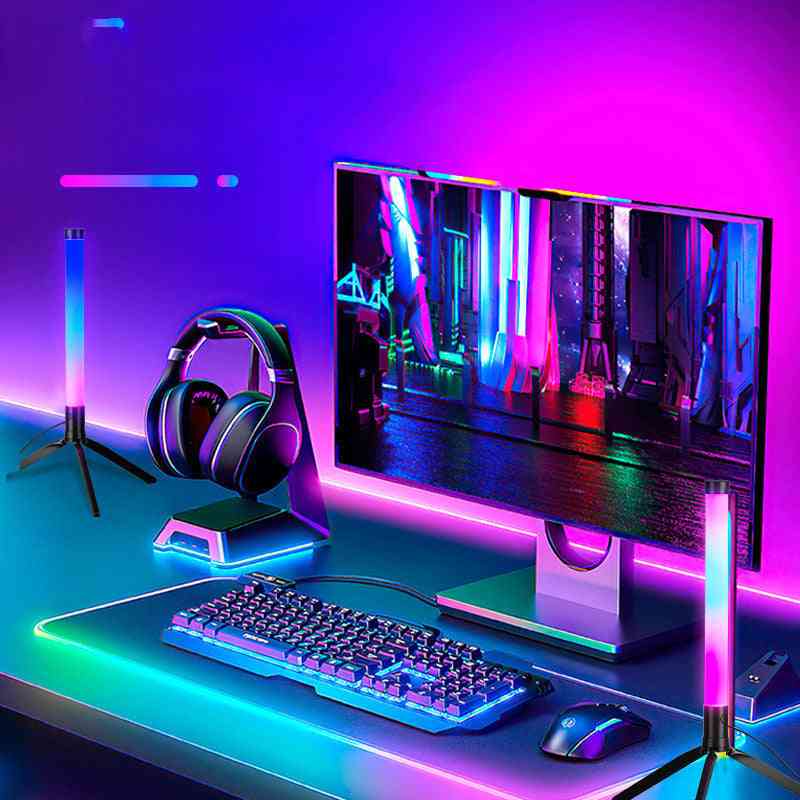 Gaming setup with monitor, keyboard, mouse, and headphones on a desk with colorful lighting.
