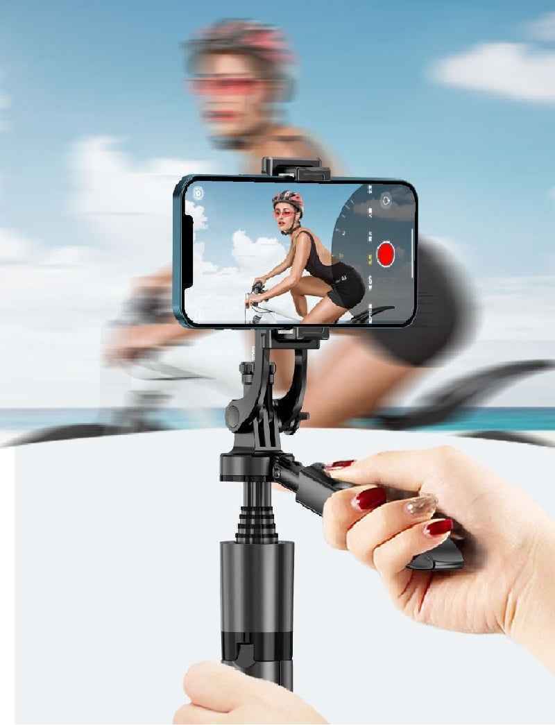 Hand holding a smartphone with a gimbal stabilizer, showing a person riding a bike on screen.