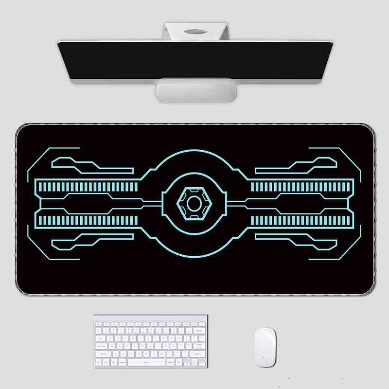 Black gaming mouse pad with white circuit design on a white surface with computer accessories.