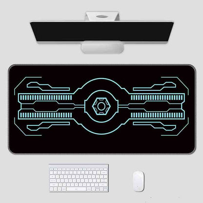 Black gaming mouse pad with white circuit design on a white surface with computer accessories.