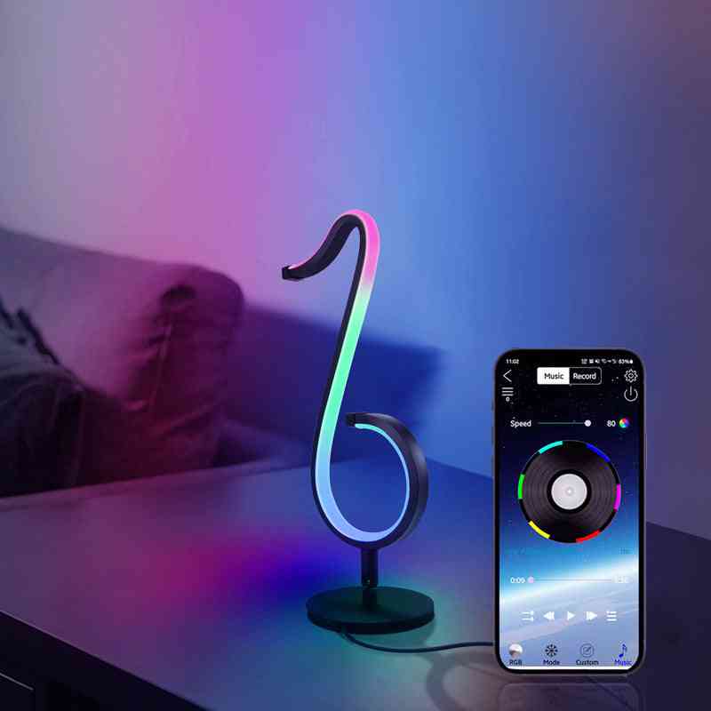 Colorful LED lamp shaped like a music note with smartphone app control on a table.