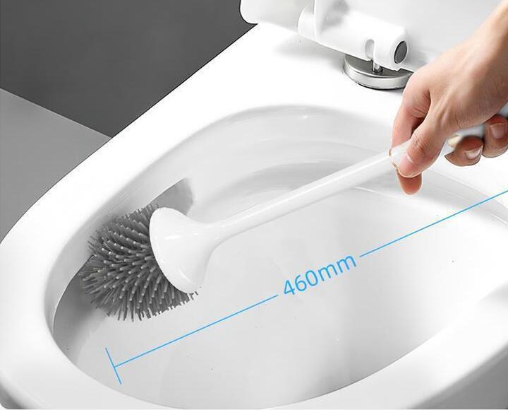 Hand using a toilet cleaning brush inside a toilet bowl with a measurement label.