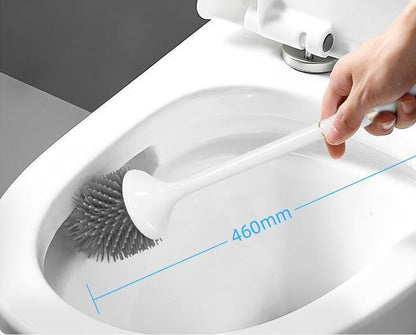 Hand using a toilet cleaning brush inside a toilet bowl with a measurement label.