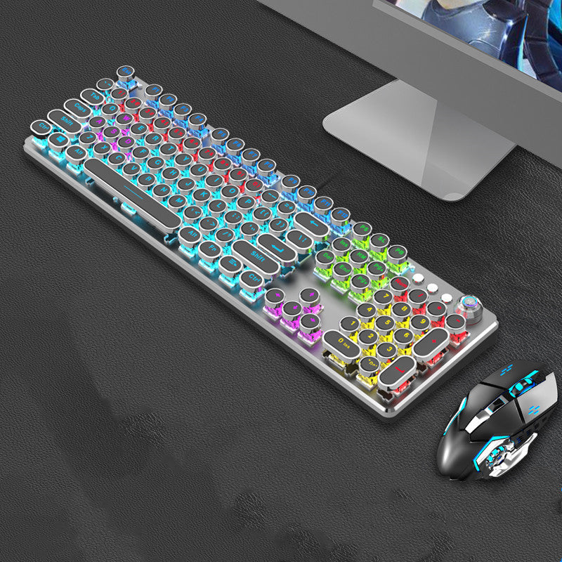 Colorful keyboard and mouse on a dark surface with a computer monitor in the background