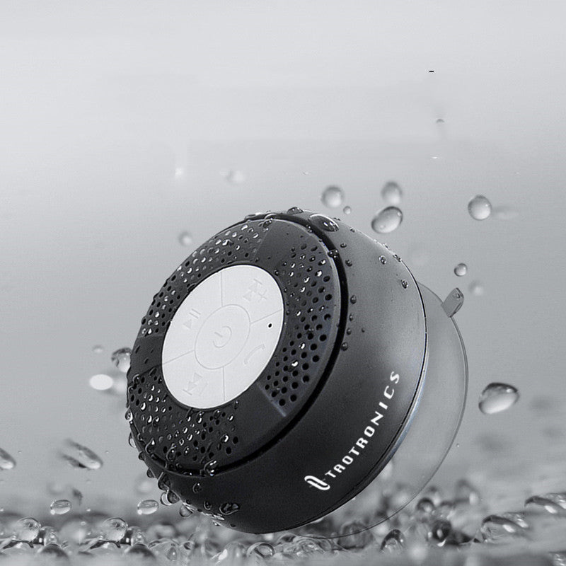 Raetronics shower speaker with water droplets on a gray background