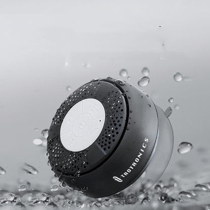 Raetronics shower speaker with water droplets on a gray background