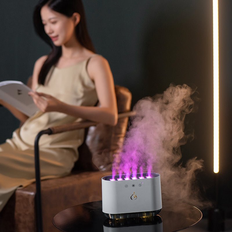 Woman reading a book with a humidifier emitting steam on a table in front of her.