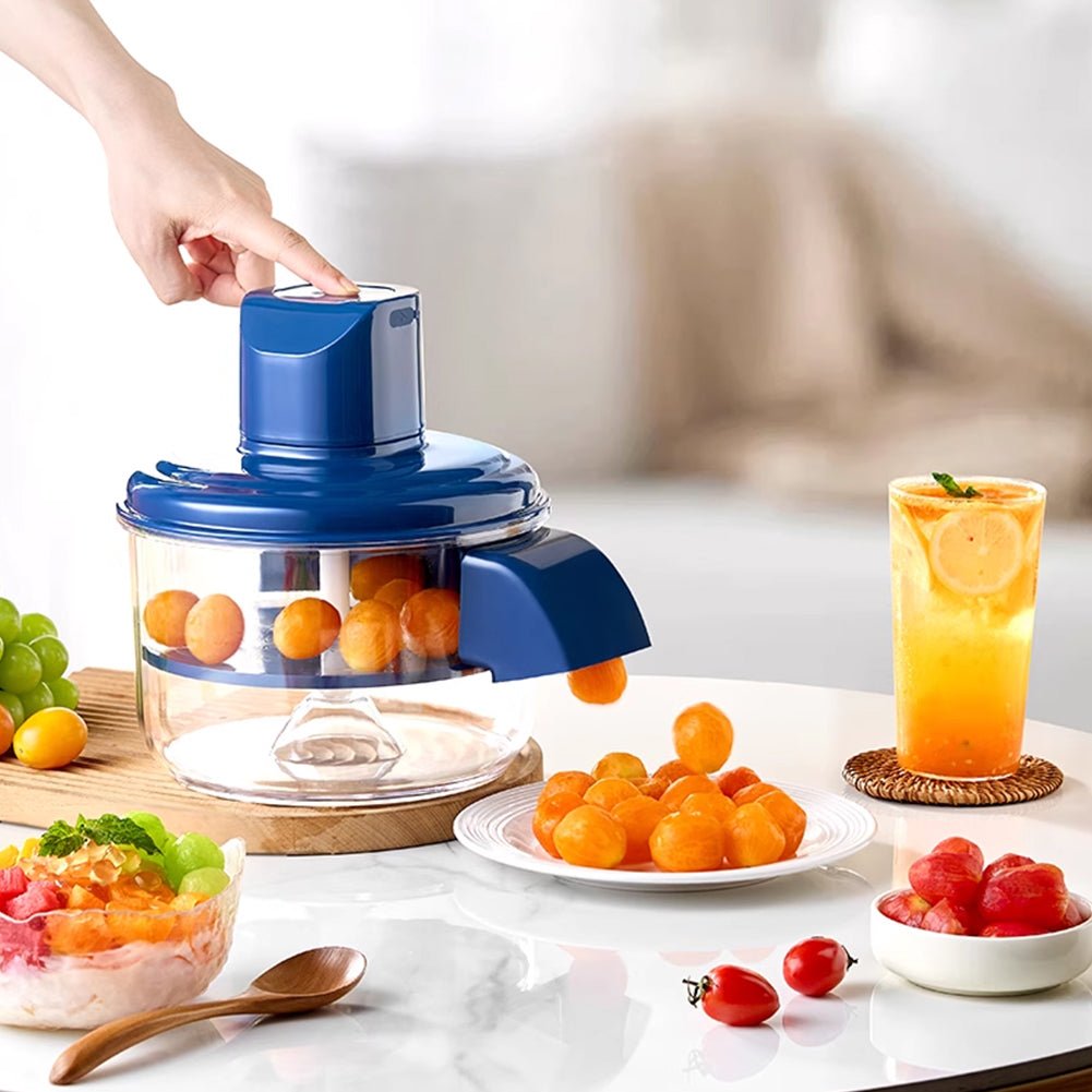 Blue manual juicer with oranges, a glass of juice, and fruits on a table.