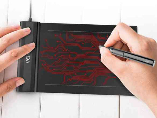 Person using a Electronic Drawing Board S640 tablet with a pen on a white surface