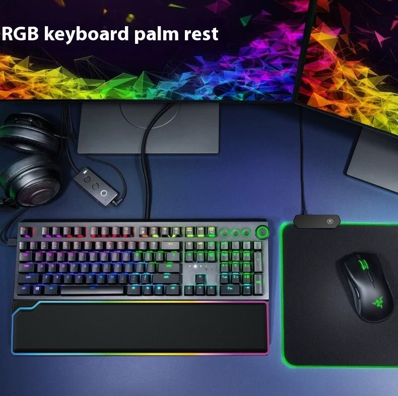 Gaming setup with RGB keyboard, mouse, and palm rest on a desk.