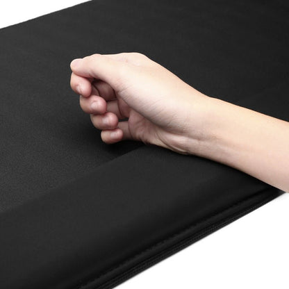 Hand on a black desk pad with a plain background