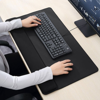 Person using a black keyboard and mouse pad on a desk