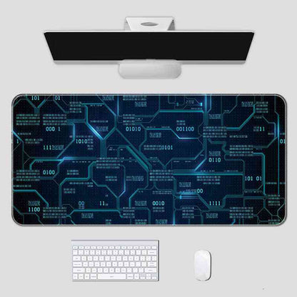 Computer setup with a large mouse pad featuring a blue circuit board design on a white surface.
