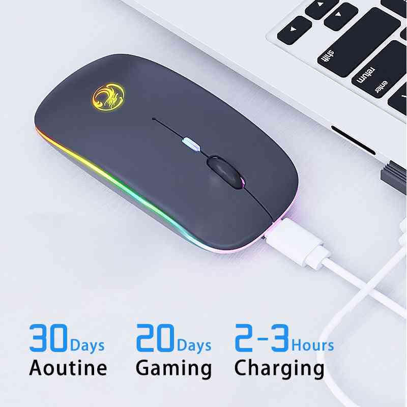 Black wireless mouse with colorful LED lights on a white surface, connected to a laptop.