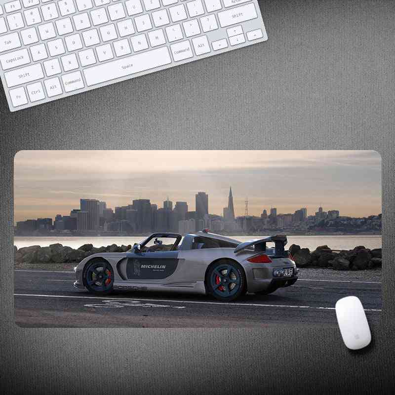 Mouse pad with a car design featuring a cityscape, keyboard, and mouse on a desk.