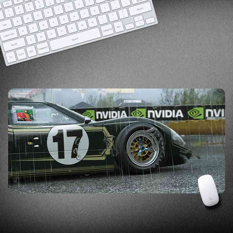 Car-themed mouse pad with a racing car design on a desk with a keyboard and mouse.