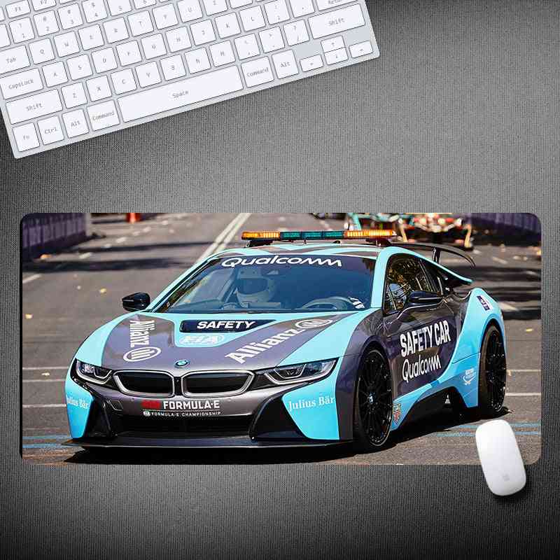Mouse pad with a racing car design on a desk with a keyboard and mouse.
