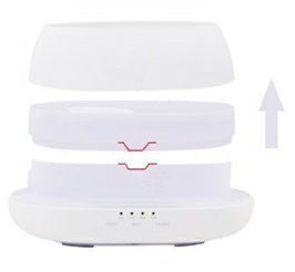 White electronic device with a lid on top, showing a charging indicator.
