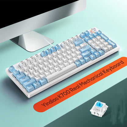 Mechanical keyboard with blue and white keys on a desk, featuring a Yindao K700 label.