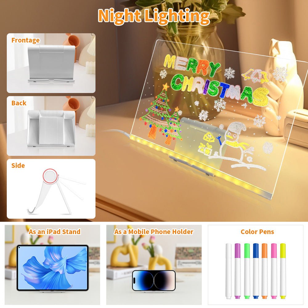 Transparent board with Christmas drawings, night lighting, and accessories on a table.