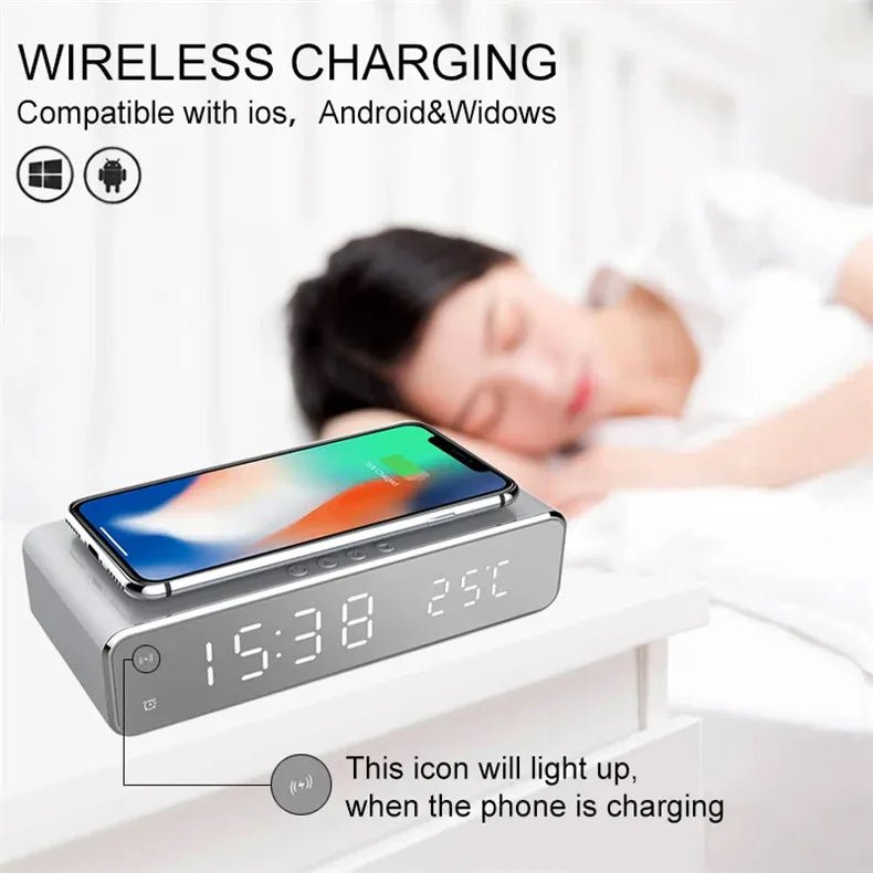 Wireless charging device with digital clock and phone on a nightstand, person sleeping in the background.