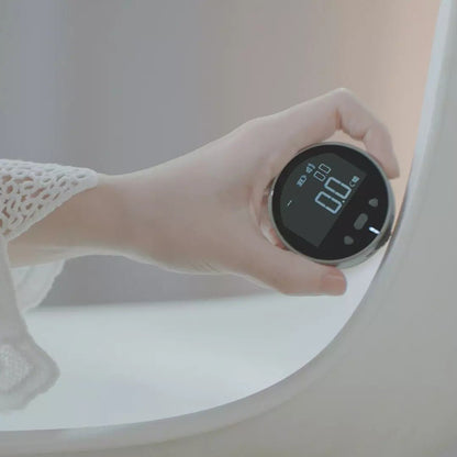 Hand holding a digital device in front of a mirror