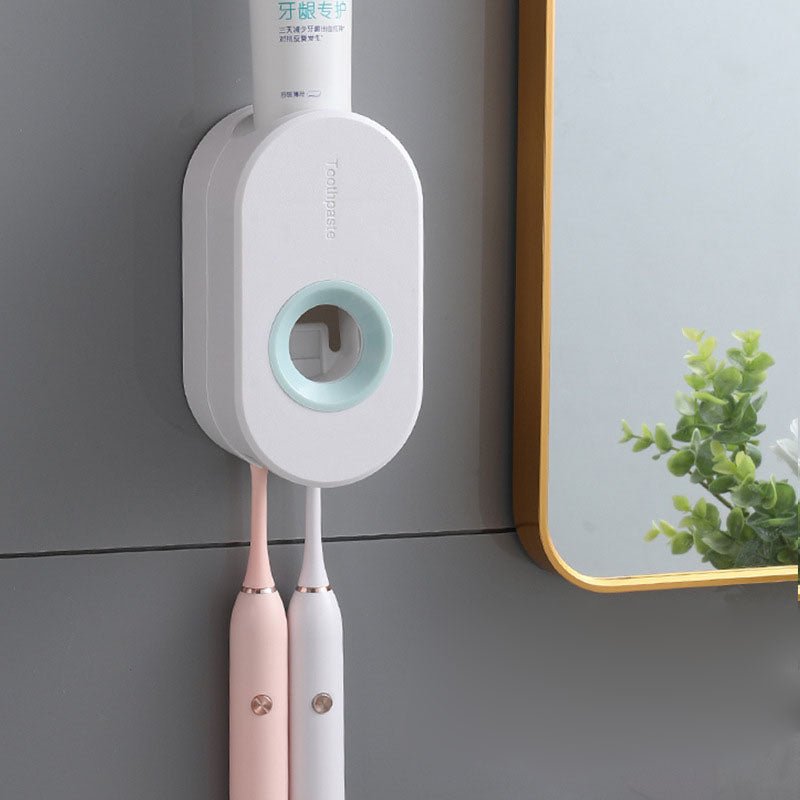 Wall-mounted electric toothbrush holder with two toothbrushes and a bottle on a gray wall.