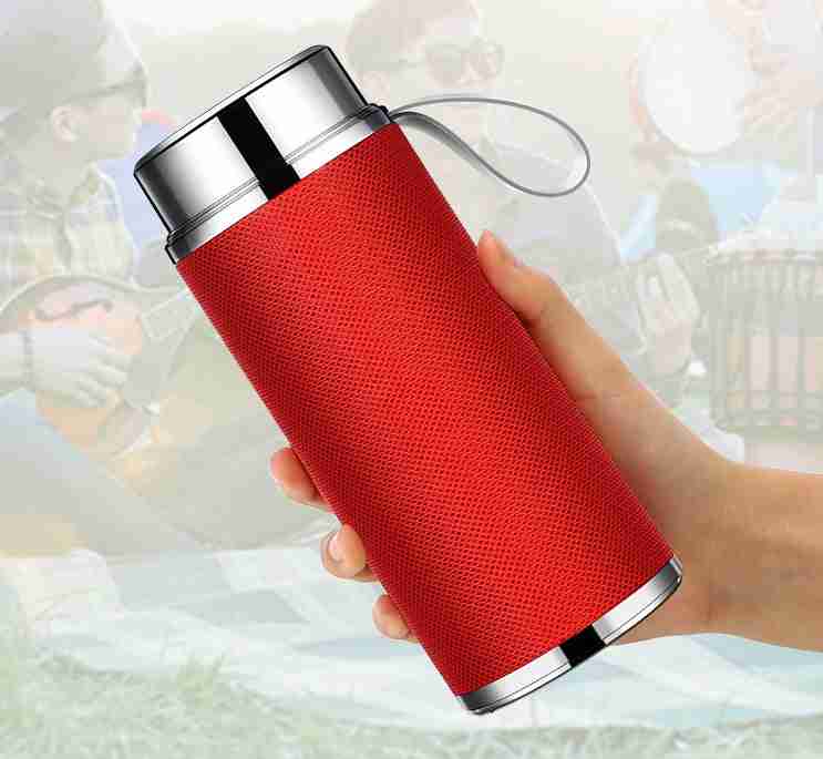 Red textured water bottle with silver cap held by a hand against a blurred background
