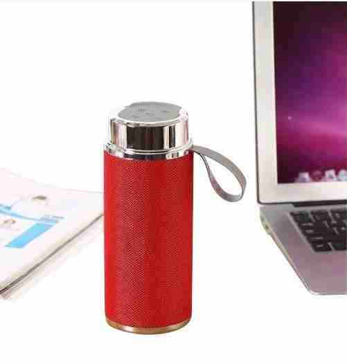 Red portable speaker with a phone and laptop on a white background