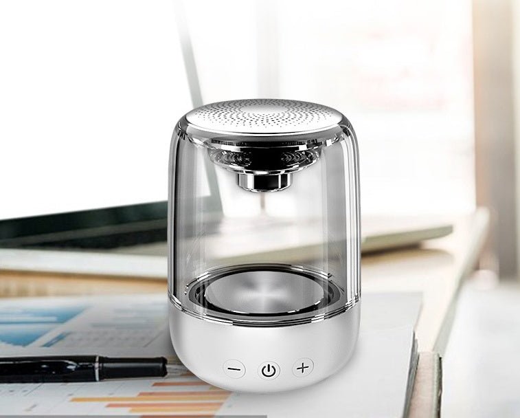 Clear cylindrical lamp with metallic accents on a desk