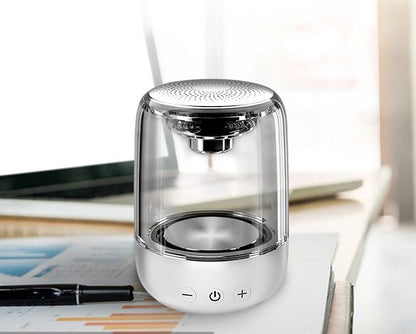 Clear cylindrical lamp with metallic accents on a desk