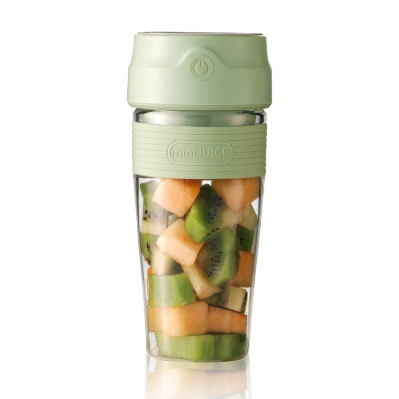 Green portable blender with fruits inside on a white background