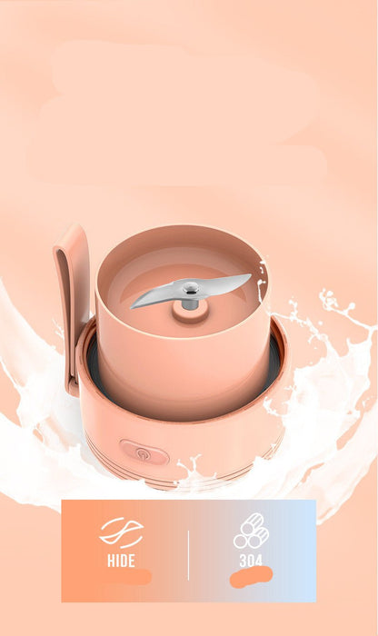 Pink electric coffee grinder with milk splash on a peach background