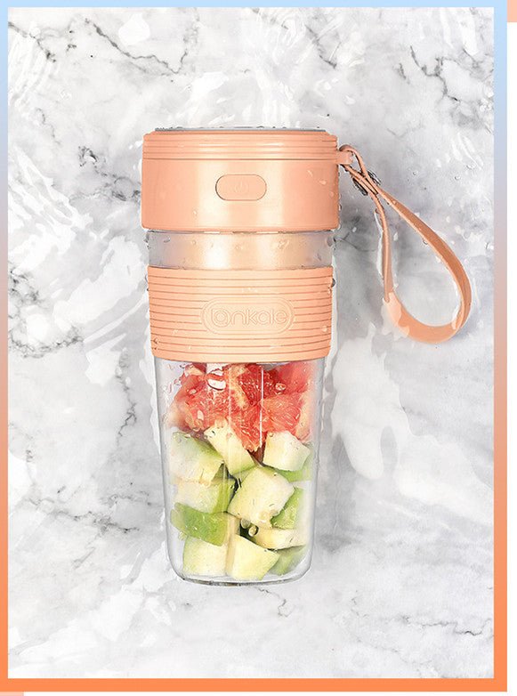 Portable blender with fruits inside on a marble background