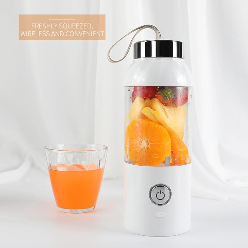 Portable blender with fruits and a glass of juice on a white background