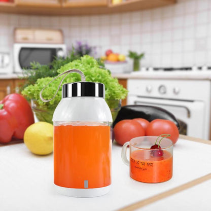 Orange juice in a thermos with a glass on a kitchen counter
