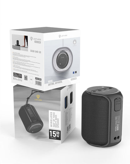 Black portable speaker with its packaging on a white background