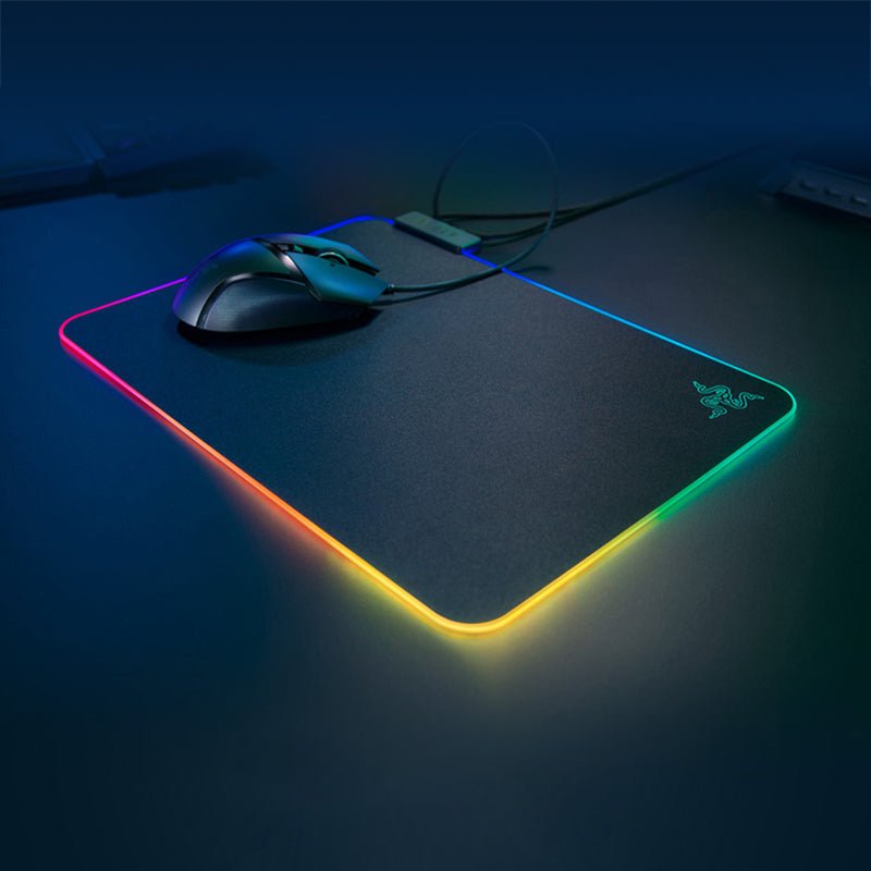 Gaming mouse and mouse pad with RGB lighting on a dark surface