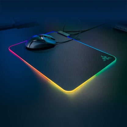 Gaming mouse and mouse pad with RGB lighting on a dark surface