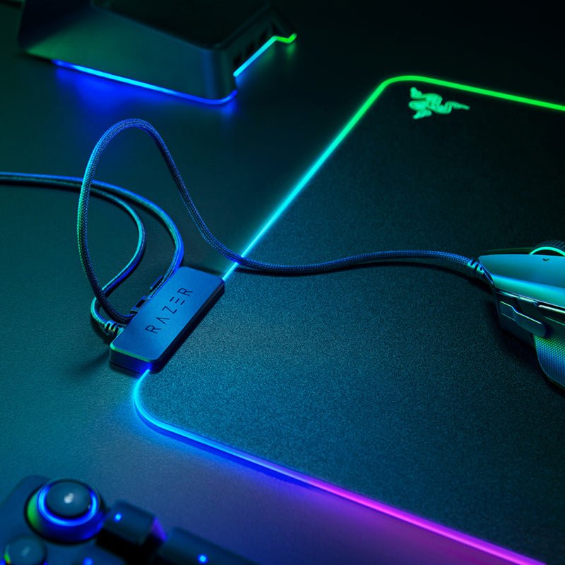 Gaming mouse, keyboard, and mouse pad with Razer branding on a dark surface.