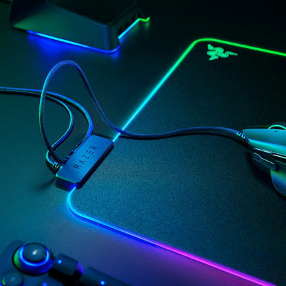 Gaming mouse, keyboard, and mouse pad with Razer branding on a dark surface.
