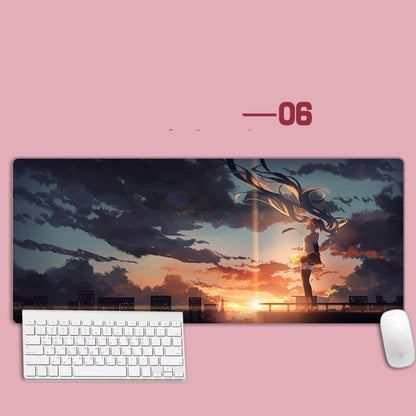 Large mouse pad with an anime-style design of a person standing on a bridge at sunset, placed on a pink surface with a keyboard and mouse in front.
