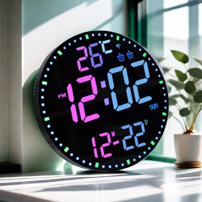 Digital clock with colorful display on a surface near a window with a plant in the background