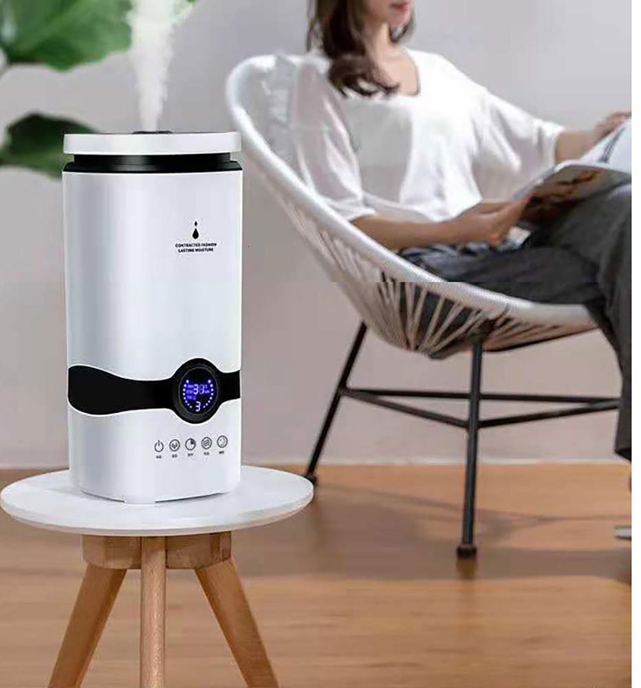 White humidifier on a small round table with a person reading in the background